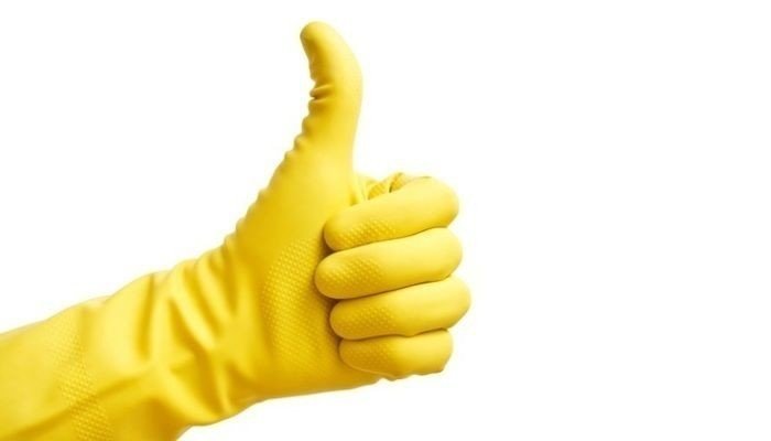 Рука в желтой резиновой перчатке
